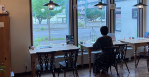 窓の外を見ながら一人で考える人物（断酒が続かない理由と生き方を見つめ直すイメージ）